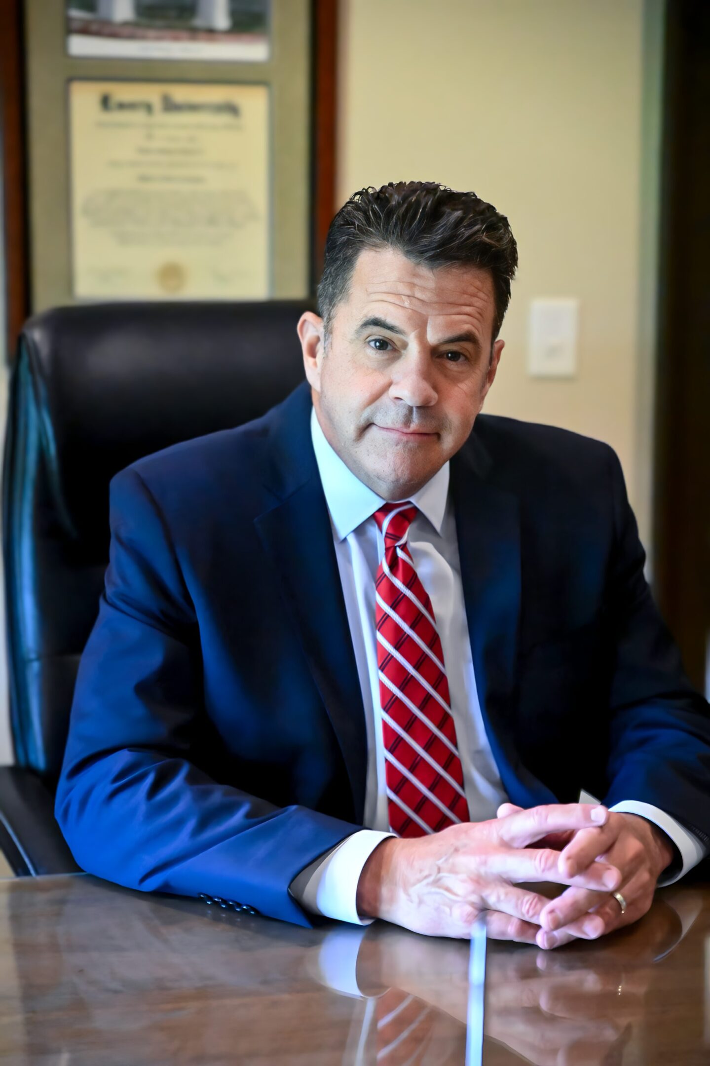 A man in suit and tie sitting at a desk.